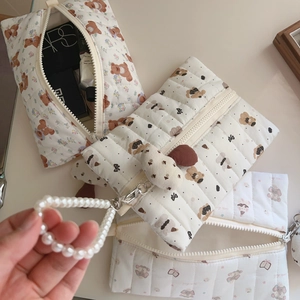 Detail view of the soft cotton quilted makeup bag with cute brown bear and floral patterns