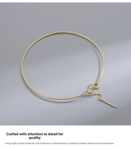 Dettaglio del bracciale minimalista in argento dorato con ciondolo a barra sottile