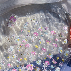 Macro shot of 3D mermaid nail stickers with iridescent sea shells and starfish details