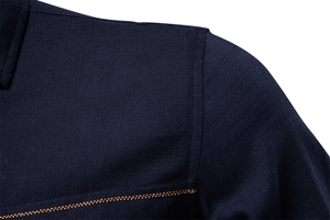 Close-up of navy blue shirt shoulder seams with decorative yellow contrast stitching
