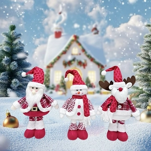 Close-up of Santa Claus, Snowman, and Reindeer plush dolls standing in a snowy Christmas scene