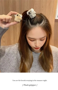 Detailed view of plush koala hair clips in grey and brown worn by a model