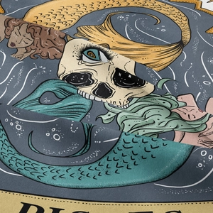 Detailed close-up of textured fabric showing Pisces zodiac print and tarot skull design