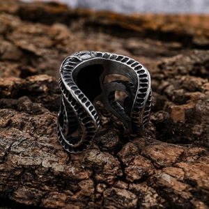 Gothic animal ram skull ring in vintage stainless steel on a textured dark wood background