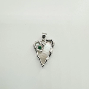 Detail of heart shell pendant with silver frame, flower accent and green zircon