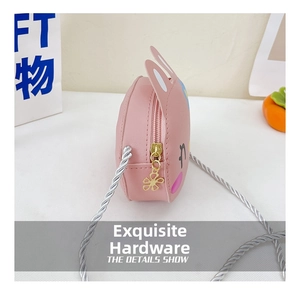 Close-up of pink rabbit bag featuring flower zipper head and woven shoulder strap