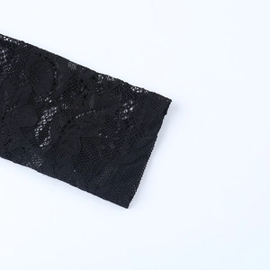 Detailaufnahme der schwarzen Spitzennähte mit eleganten Ausschnitten am Kleid