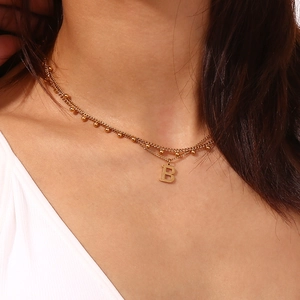 Close-up of 18K gold-plated double-layer necklace with beaded chain and letter B pendant