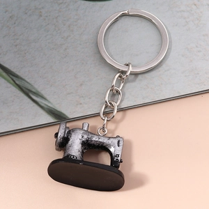 Detailed macro view of a vintage sewing machine keychain with antique silver metal finish