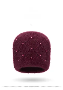 Vista frontale del berretto a maglia bordeaux con motivo a rombi e perle decorative