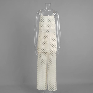Detailed close-up showing the draped fabric of the polka dot top and wide-leg trousers