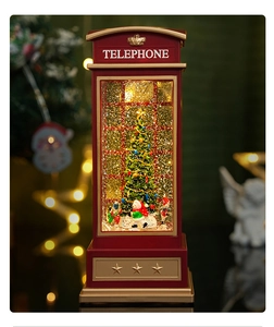 Close-up of a festive red Christmas telephone booth music box with glowing snow scene