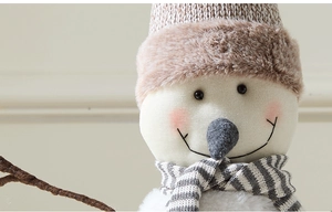 Detail of plush Christmas snowman ornament with knit hat and striped scarf decoration
