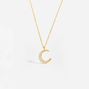 Macro shot of gold S925 sterling silver crescent moon pendant set with cubic zirconia