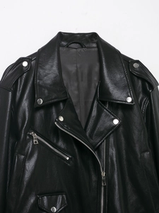 Detail of black faux leather motorcycle jacket with silver diagonal zipper and metal snaps