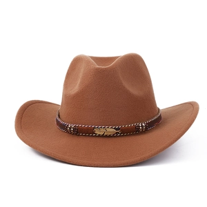 Détail d'un chapeau de cowboy marron avec plume dorée et décorations de perles