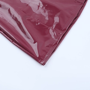 Detailansicht aus weinrotem PU-Lackleder mit präzisen Nähten für ein figurbetontes Kleid