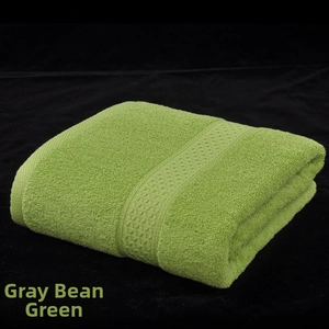Close-up of sage green cotton bath towel with textured loop structure and woven border