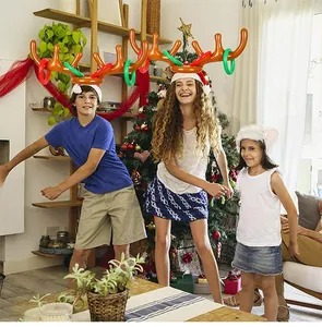 Teens playing inflatable reindeer antler toss game in a cozy Christmas living room scene