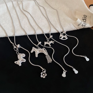 Macro detail of five S925 silver horse pendants with zircon on snake chains