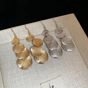 Irregular matte sequin tassel earrings in gold and silver finish with layered round discs