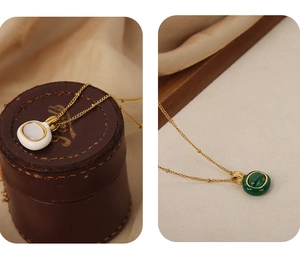 Detail of 18k gold plated necklaces with white shell and green malachite stone pendants