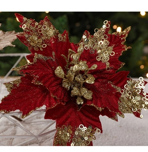 Close-up of red velvet Christmas flower with gold sequins on a warm festive tree