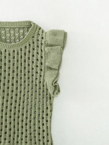 Detail of green knit top featuring delicate hollow-out mesh texture and ruffle sleeve cuffs