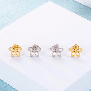 Set of four flower stud earrings in gold and silver finish on professional display stand
