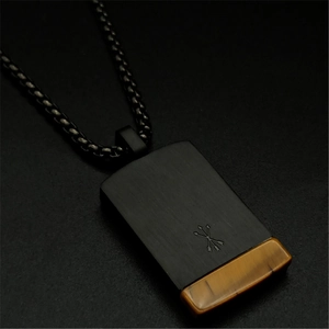 Macro detail of square black metal pendant featuring natural yellow tiger eye stone inlay