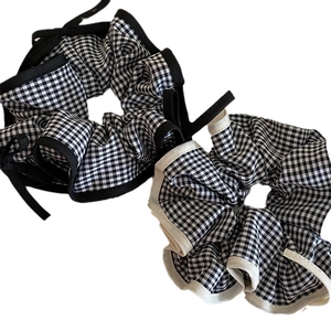 Set of black and white checkered scrunchies with bow tie details on white background
