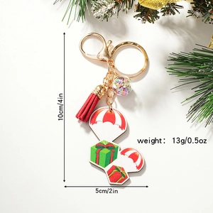 3D cartoon Christmas hot air balloon keychain with gift boxes and red tassel on white background