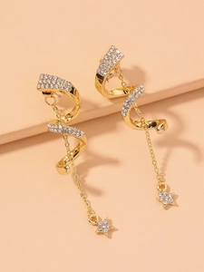 Détail de boucles d'oreilles spirales dorées avec strass et pendentifs étoile cristal