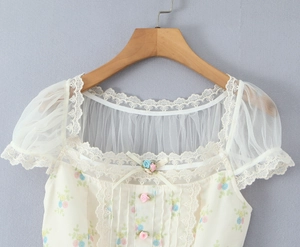 Détail du haut à fleurs avec dentelle au col et manches bouffantes en tulle transparent