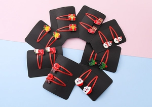 Close-up of assorted resin Christmas hair clips with Santa and Reindeer on red glitter base