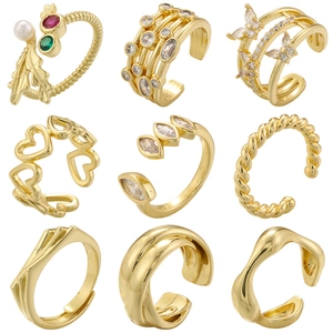 Set of nine golden rings featuring leaf, butterfly, and heart designs with zircon inlays