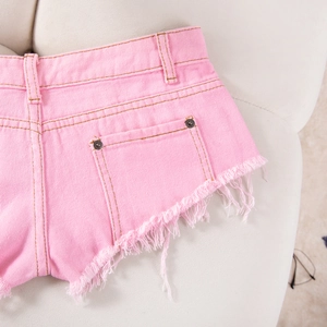 Nahaufnahme der rosa Denim-Shorts mit ausgefransten Kanten und Metallnieten-Taschen