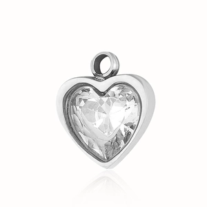 Macro detail of a heart-shaped silver pendant with clear gemstone and steel loop