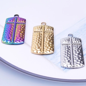 Detailed view of hammered cross pendants in rainbow, gold and silver finishes