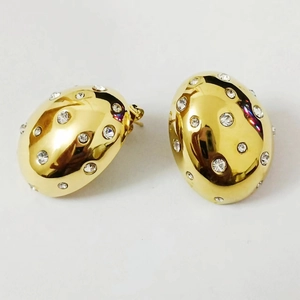 Detail of gold oval stud earrings featuring geometric pavé set sparkling zircon stones