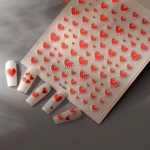 Detail of red heart nail stickers with gold bead edges and 3D embossed texture