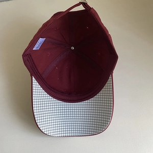 Burgundy cotton baseball cap with embroidered star and plaid brim detail, top view
