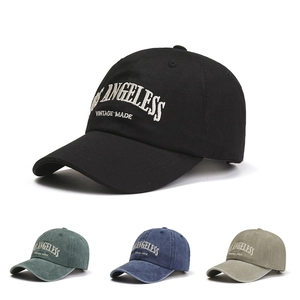 Detail of vintage baseball caps showing embroidery and washed canvas texture in four colors
