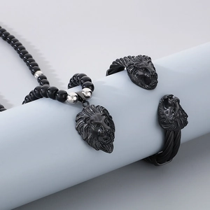 Detail of lion head bracelet and black bead necklace set on a cylindrical prop display