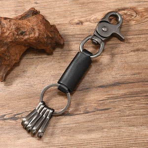 Detail of leather car keychain with gunmetal clips and rings on a wooden background