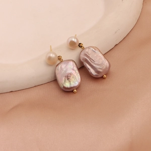 Detailed view of iridescent baroque pearls and purple luster on a silk backdrop