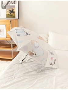 Detailed view of cream-colored umbrella featuring cute cartoon cat and fishbone patterns