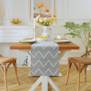 Nordic gray ripple cotton linen table runner with geometric patterns on a wooden table