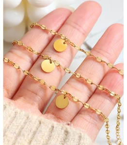 Detail of 18k gold plated titanium steel chain with multiple polished round pendants