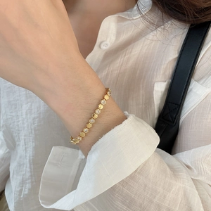 Macro detail of 18k gold plated geometric honeycomb bracelet with sparkling zircon stones